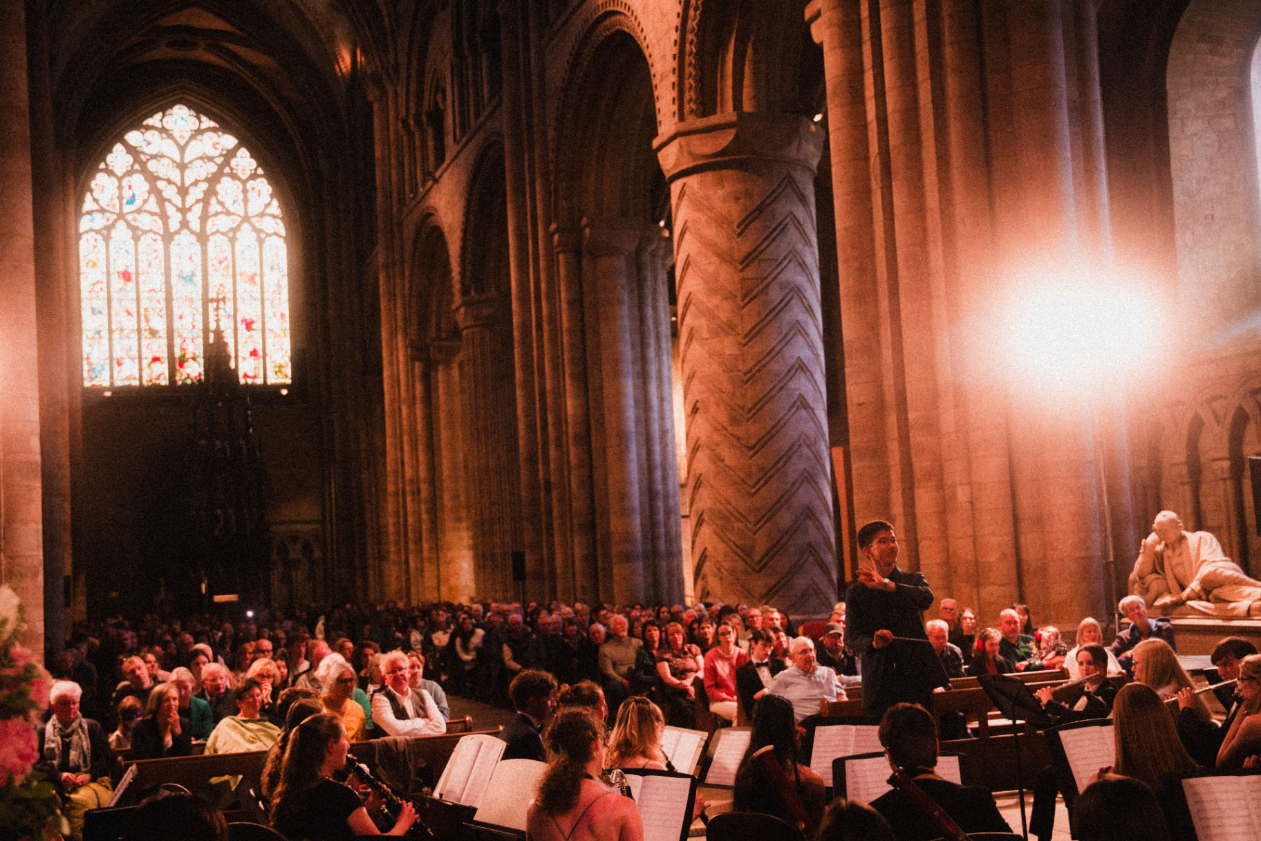 Conductor leading orchestra inside a cathedral